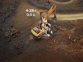 Aerial view of an excavator loading a truck with data overlay